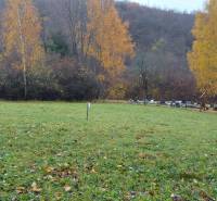 Travnaté rekreační pozemky na Jeseni v Podhradí, Konské, s barevnými listnatými stromy v pozadí.