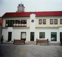 Obchodní prostory na Štúrově náměstí v Trenčíně s věží v pozadí.