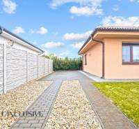 Rodinný dům v Gabčíkovu se zpevněnou příjezdovou cestou, kamenným plotem a udržovaným trávníkem.