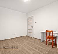 Interiér rodinného domu s pracovním stolem, židlí a podlahou s dřevěným dekorem.