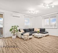 Obývací pokoj v rodinném domě s rohovou sedačkou a podlahou s dřevěným dekorem.