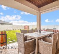 Terasa rodinného domu v Gabčíkovu s ratanovým nábytkem a výhledem na zahradu.