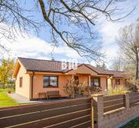 Rodinný dům v Bíkových Humencích s předzahrádkou a stromy na upraveném pozemku.