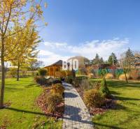 Zahrada v Bílkovej Humenci s altánkem a stromy ozdobenými barevnými listy v rodinném domě.