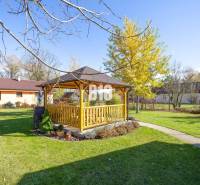 Zahrada rodinného domu v Bílkových Humencích s altánkem a upraveným trávníkem.