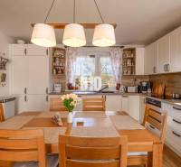 Kuchyně v rodinném domě s dřevěným dekorem a jídelním stolem.
