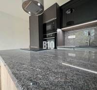 Kuchyně v 2-pokojovém bytě s mramorovou deskou a moderním vybavením.