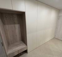 Vestavěná skříň s háčky a poličkou v 2-pokojovém bytě.