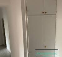 Bílý vestavěný úložný prostor a dlažba v 2-pokojovém bytě.