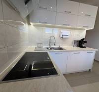 Elegantní kuchyně v 3-pokojovém bytě s bílými skříňkami a indukční varnou deskou.