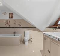 Koupelna v rodinném domě s vanou, toaletou a dekorativními nálepkami na stěnách.