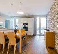 Kuchyně v rodinném domě s cihlovou stěnou a podlahou s dřevěným dekorem.