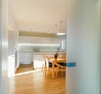 Kuchyně v rodinném domě s podlahou s dřevěným dekorem a jídelním stolem.