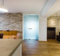 Jídelna rodinného domu s cihlovou stěnou a podlahou s dřevěným dekorem.