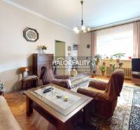 Obývací pokoj s rustikálním nábytkem, květinami a podlahou s dřevěným dekorem v rodinném domě.