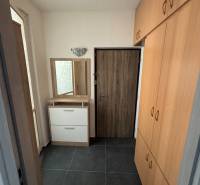 Chodba s tmavou dlažbou a vestavěnou skříní v 3pokojovém bytě.