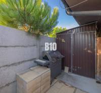 Zahrada v Mostě u Bratislavy s grilem a dřevěným přístřeškem u rodinného domu.