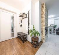 Interiér rodinného domu s podlahou s dřevěným dekorem, kamenným krbem a pohodlným obývacím pokojem.