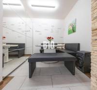 Interiér rodinného domu s posezením, zrcadlovou stěnou a dekorativním obkladem.