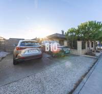 Dvorek rodinného domu v Mostě u Bratislavy s parkovacími místy a zaparkovanými auty.