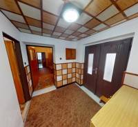 Chodba v rodinném domě, obložené stěny a podlaha s dřevěným dekorem.