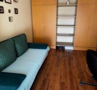 Pokoj v 3-pokojovém bytě s podlahou s dřevěným dekorem a vestavěnými skříněmi.