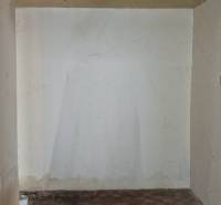 Interiér rodinného domu s poškozeným stropem a podlahou se stopami poškození.