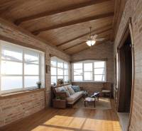 Interiér rodinného domu s cihlovými stěnami, podlahou s dřevěným dekorem a pohodlným sezením.