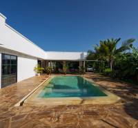 Bílá architektura s bazénem uprostřed zeleně v Paje, Unguja South Region.