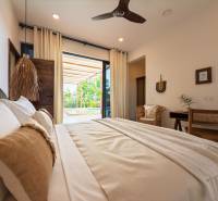 Interiér ložnice s prostornou postelí a výhledem na terasu, Výstavba domů.