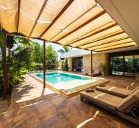 Zahrada rodinného domu na ulici Paje v regionu Unguja South s bazénem a lehátky.