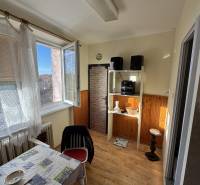 Jídelna v 3-pokojovém bytě s podlahou s dřevěným dekorem a otevřeným oknem.