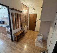 Interiér 3-pokojového bytu s podlahou s dřevěným dekorem a věšákem na stěně.