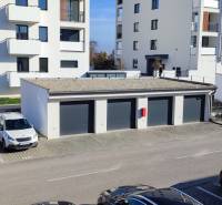 Pohled na Predmerského ulici v Trenčíně s bytovým domem a parkováním.