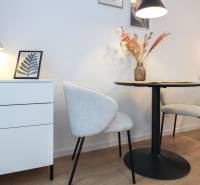 1-pokojový byt s dekorativními židlemi, stolem a lampou na podlaze s dřevěným dekorem.