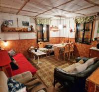 Rustikální interiér chaty s pohovkami, dřevěným dekorem a dekoracemi v útulné atmosféře.