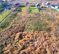 Letecký pohled na pozemky pro bydlení v Radnovcích s venkovskými domy a zelení.