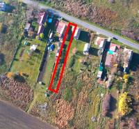 Pohled shora na pozemky k bydlení v Radnovcích, obklopené přírodou a nedalekou cestou.