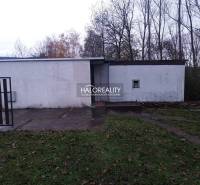 Rekreační pozemky v Nitrianskem Rudnu s jednoduchou stavbou obklopenou přírodou a stromy.