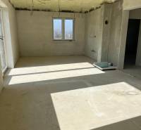 Prostorná místnost v rodinném domě na ulici Vyšná Šebastová se surovou omítkou a kabely.