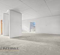 Prázdný interiér v rodinném domě s bílými stěnami a velkými okny.