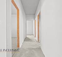 Neomítnutá chodba v rodinném domě s povrchy připravenými k dokončení.