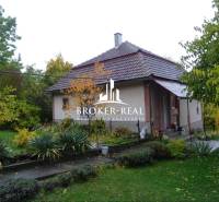 Rodinný dům ve Fony s velkou zahradou, obklopený zelení a stromy.