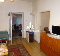 Obývací pokoj v rodinném domě s kobercem a podlahou s dřevěným dekorem.