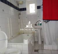 Koupelna s vanou a bílými kachličkami v rodinném domě.