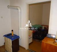 Interiér rodinného domu s topným tělesem, nábytkem a podlahou s dřevěným dekorem.