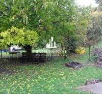 Zahrada u rodinného domu ve Fony, s posezením z palet a ohništěm.