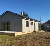 Rodinný dům v Tesárskych Mlyňanoch s neomítnutou fasádou a betonovou terasou.