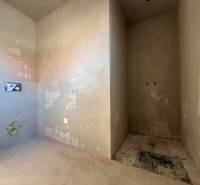 Nedokončená koupelna v rodinném domě s přípravou na instalace.