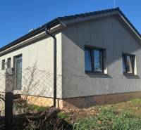 Rodinný dům v Tesárskych Mlyňanoch s šedou fasádou a okny, oplocený plotovým pletivem.